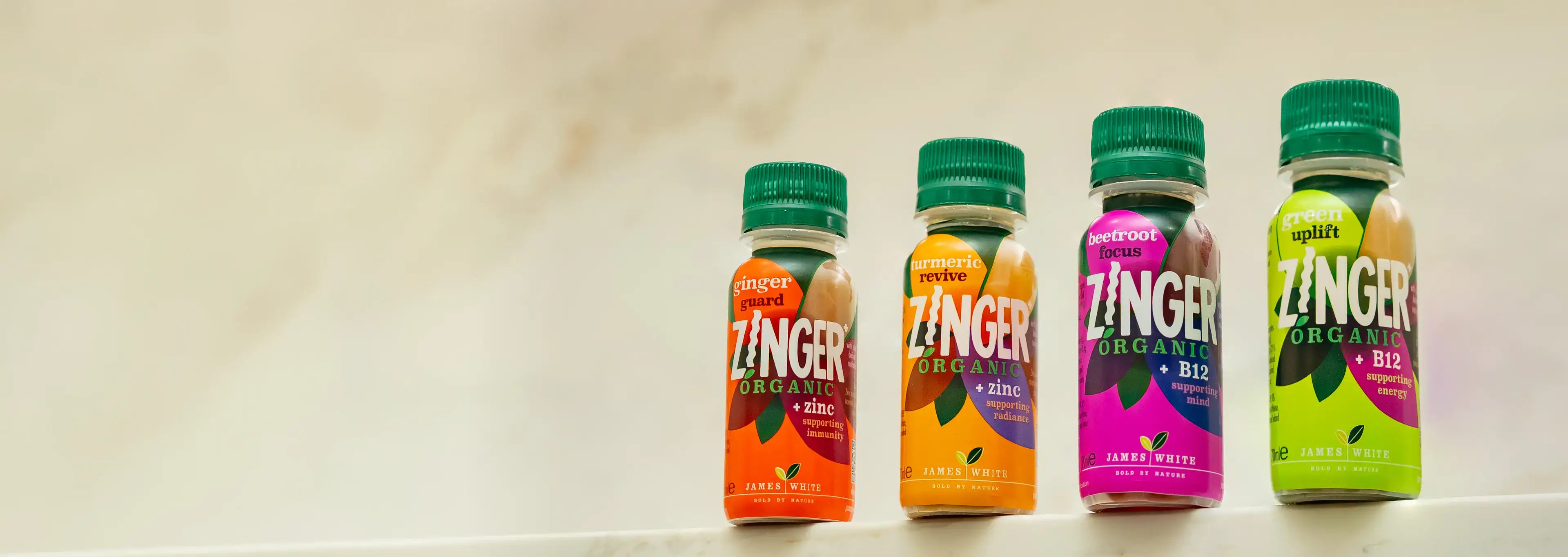 The four Zinger Organic shot flavours standing on a pale stone surface