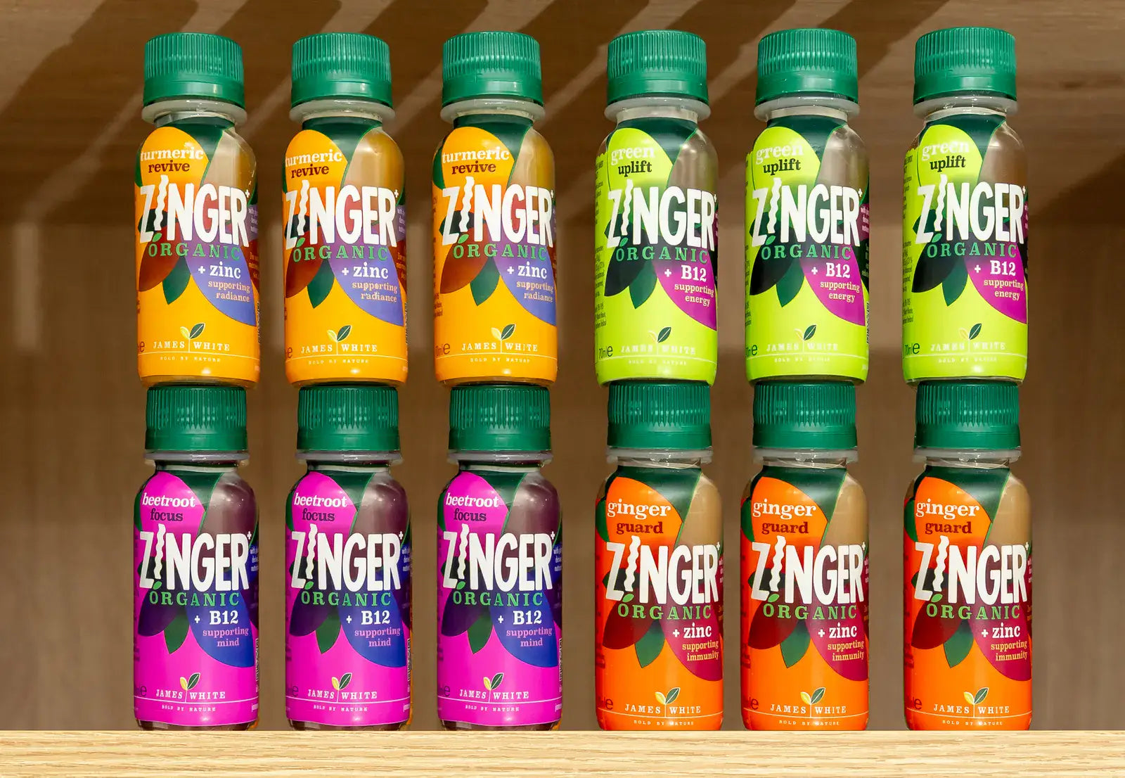 A mixed box of twelve Zinger Organic shots arranged on wooden shelves