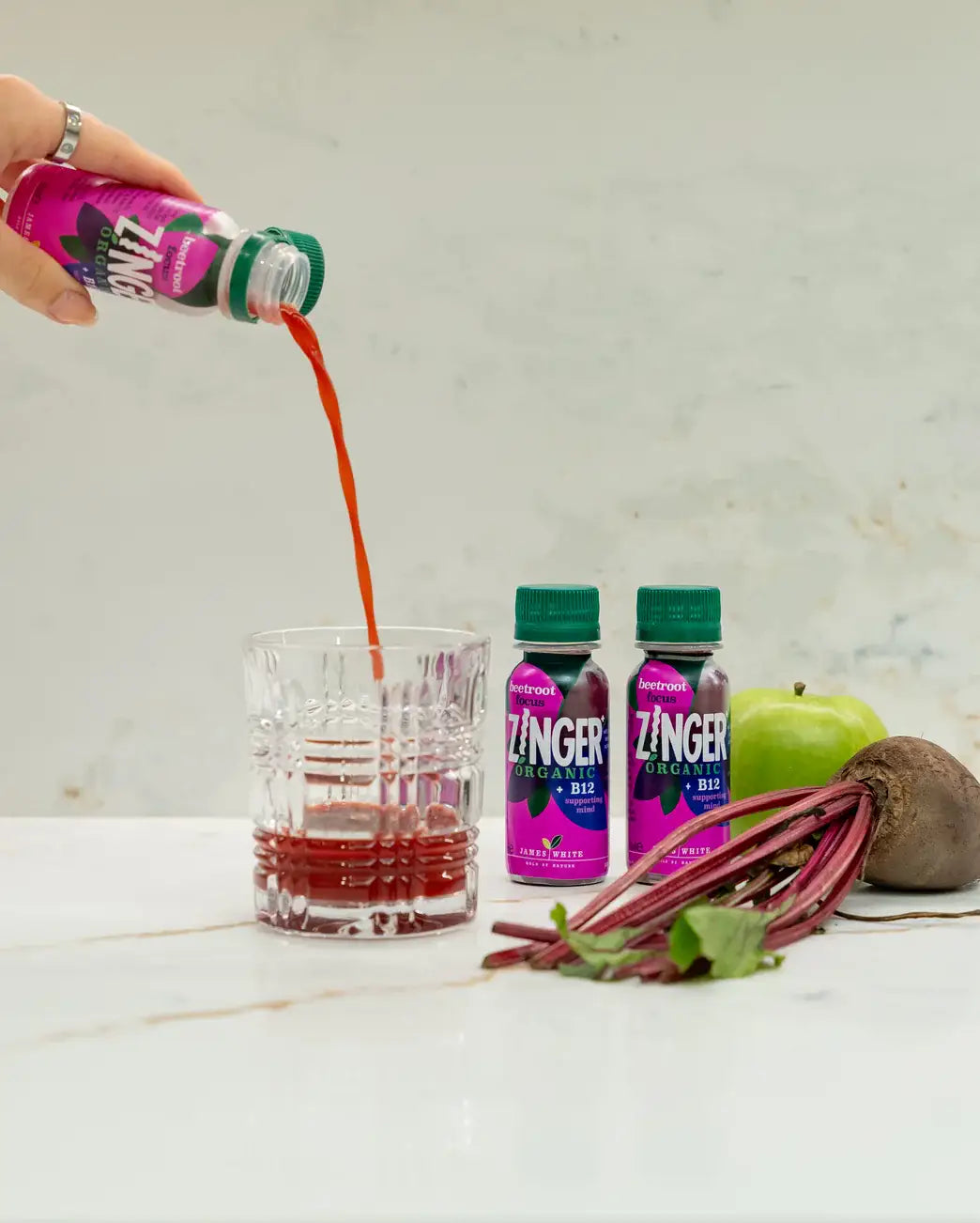 Beetroot Focus poured into a glass beside fresh beetroot and apple